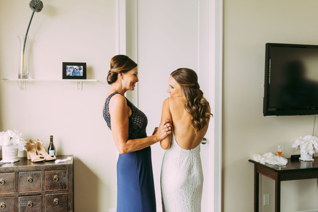 mom and daughter putting on dress