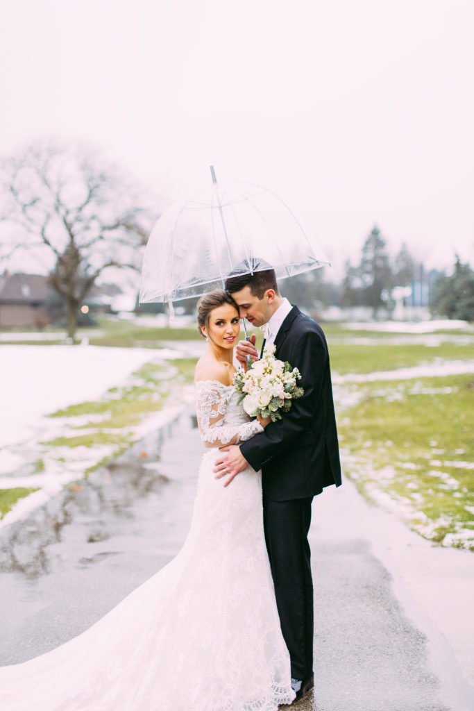 A rainy wedding day in Michigan outdoor with umbrella 